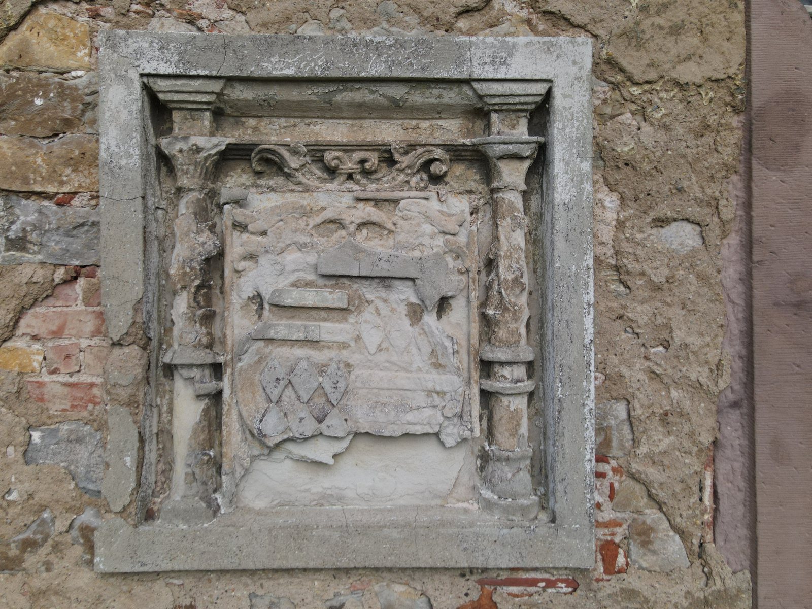 Verwittertes Wappenrelief an der Fassade von Schloss Seeburg